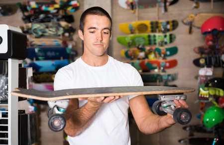 Portrait of adult man choosing new skateboardの写真素材