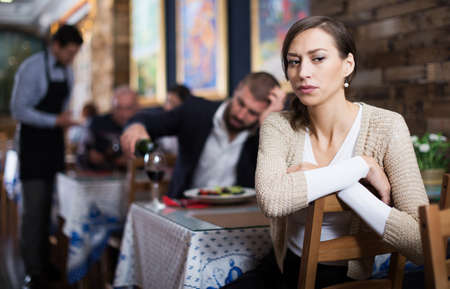 quarreled visitors female and male in restaurantの写真素材