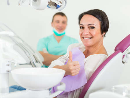 patient female thumbs up in medical roomの写真素材