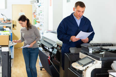 Team of professionals works on printing equipmentの写真素材