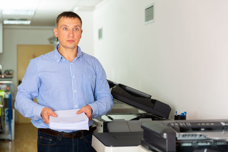 Office worker puts a stack of paper in the printer