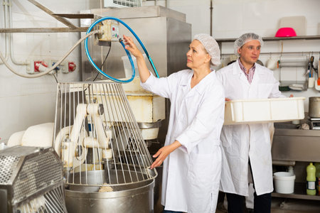 Bakery workers watching work of kneading machine