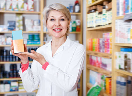 Mature seller recommending skin care productsの写真素材