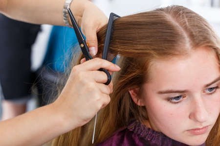 Closeup of teen girl getting haircuttingの写真素材