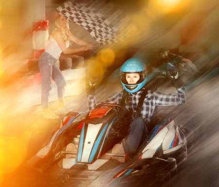 Pretty female go-cart racer crossing finish lineの写真素材