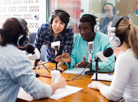 Scandal interview. Two outraged guests answering provocative questions of radio hosts during live radio showの写真素材