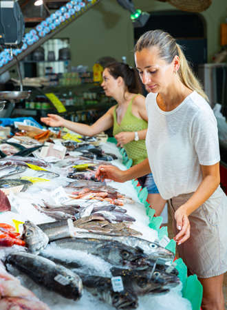 Female customers choosing seafoods at storeの写真素材
