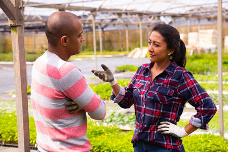 Two latino garden workers discussing working processの写真素材