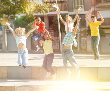 Boys and girls jumping at sunny dayの写真素材