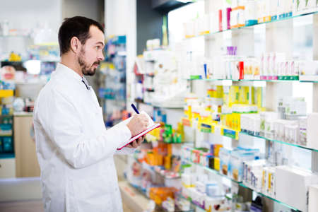 Pharmacist checking drugs in pharmacyの写真素材