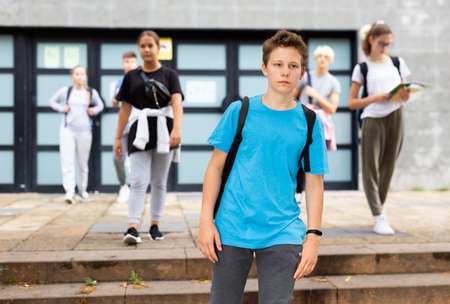 Teenager walking outside college building in autumn dayの写真素材