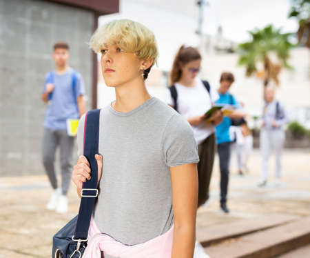 Teenager walking outside college building in autumn dayの写真素材