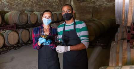 Two winemakers posing with wine in glasses