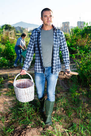 Confident smiling young man ready to work in home gardenの写真素材