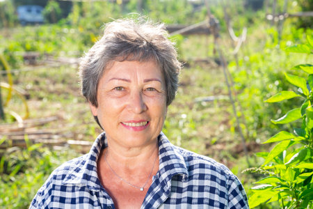 Cheerful aged woman ready to work in home garden