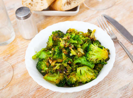 Fried broccoli with spices on a plateの写真素材