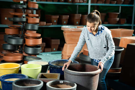 Woman choosing big pot for plantsの写真素材