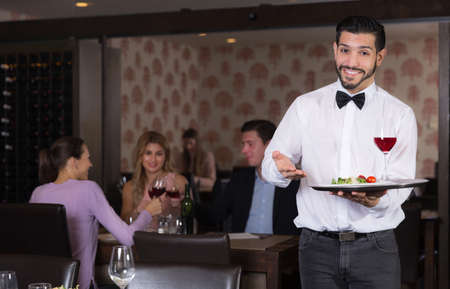 waiter with serving tray meeting guestsの写真素材