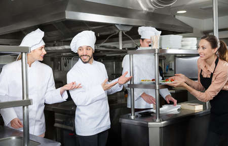 Chef checking dishes in kitchen of restaurantの写真素材