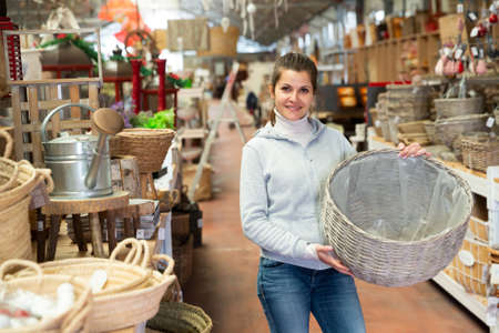 Woman looking for wickerwork in shopの写真素材