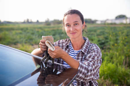 Female farmer posing near car on farmの写真素材