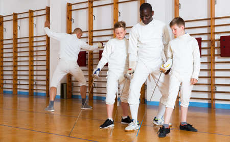 Coach demonstrating fencing movements to kidsの写真素材