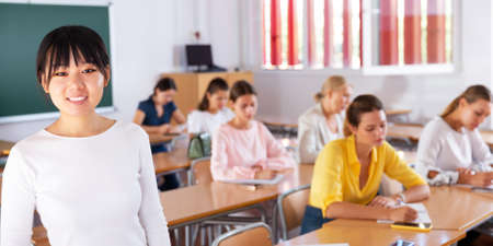 Asian female student standing in classroomの写真素材