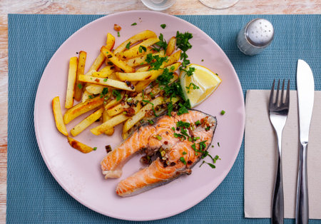 Tasty grilled salmon served with french fries