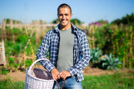 Positive young gardener posing in vegetable gardenの写真素材