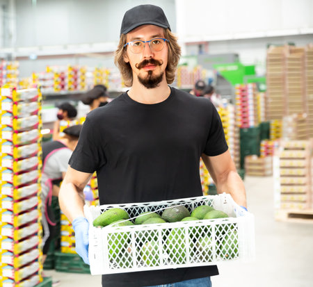 Portrait of a worker with a box of mango fruits
