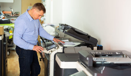 Worker is printing a file, document in the office room