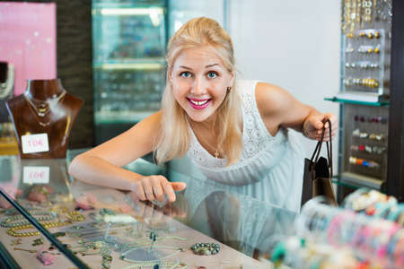 Portrait of young woman standing next to glass showcasesの写真素材