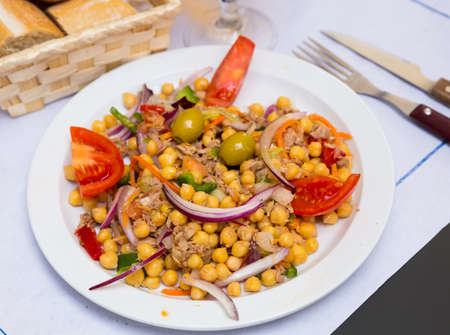 Salad with tomatoes, olives with garbanzos and onion in restauranteの写真素材