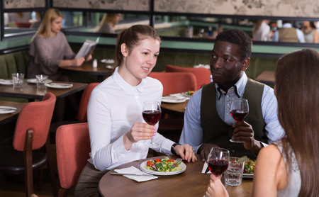 Happy couple with female friend in restaurant
