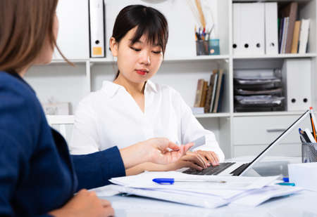 Asian woman working with clientの写真素材