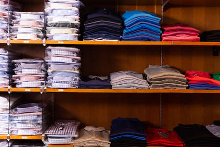 Clothing store. Shelves with shirts of different sizesの写真素材