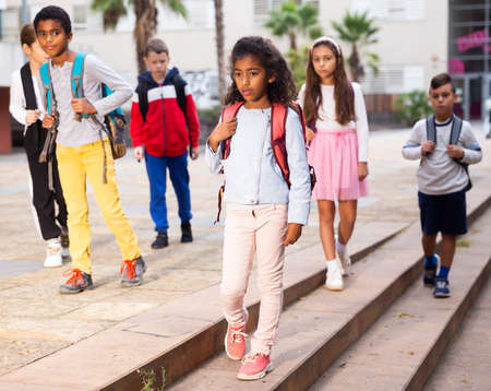 Schoolchildren walking together on the street from schoolの写真素材