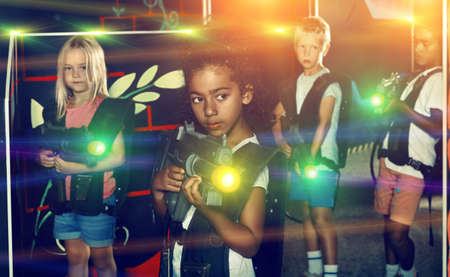 Teenager girl with laser pistol posing in laser tag labyrinthの写真素材