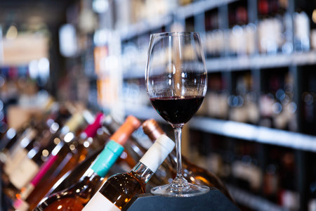 Red wine glass in wine store interior