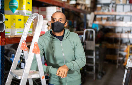 Buyer in protective mask chooses stepladder at hardware storeの写真素材