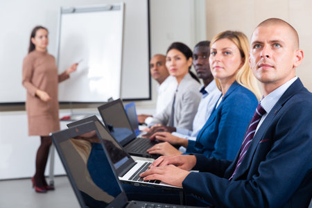Side view of managers group working at laptops in office