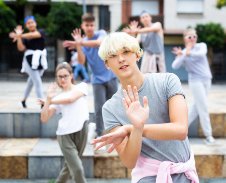 Teen boy dancing modern street dance with teenagers