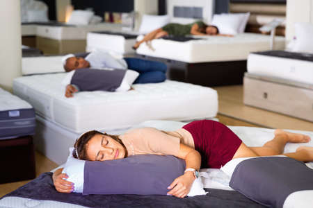 Young woman fell asleep on new mattress in a furniture storeの写真素材
