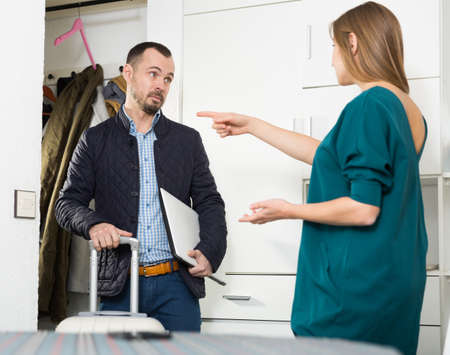 Woman pointing at door to boyfriendの写真素材