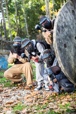 Paintball players aiming outdoors