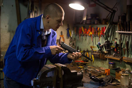 Repair and lubrication of pistol in weapons workshopの写真素材