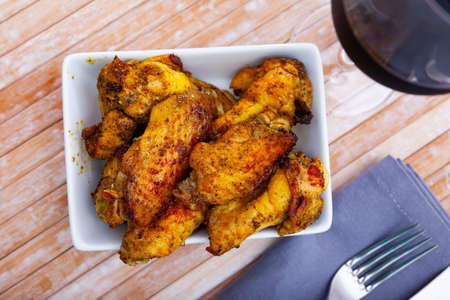 fried hot chicken wings on white plate for brunchの写真素材