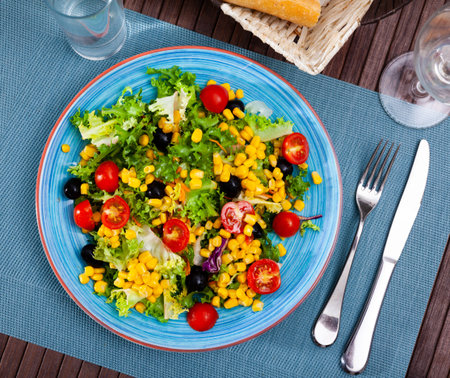 Salad with lettuce, tomato, corn and olivesの写真素材