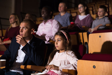Family watching a movie in cinema hall
