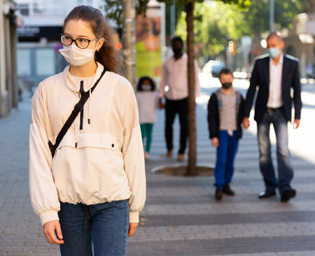 Portrait of teen girl student in face mask on her way to collegeの写真素材